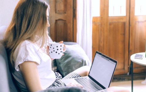 Woman logging in from home to hybrid work job.