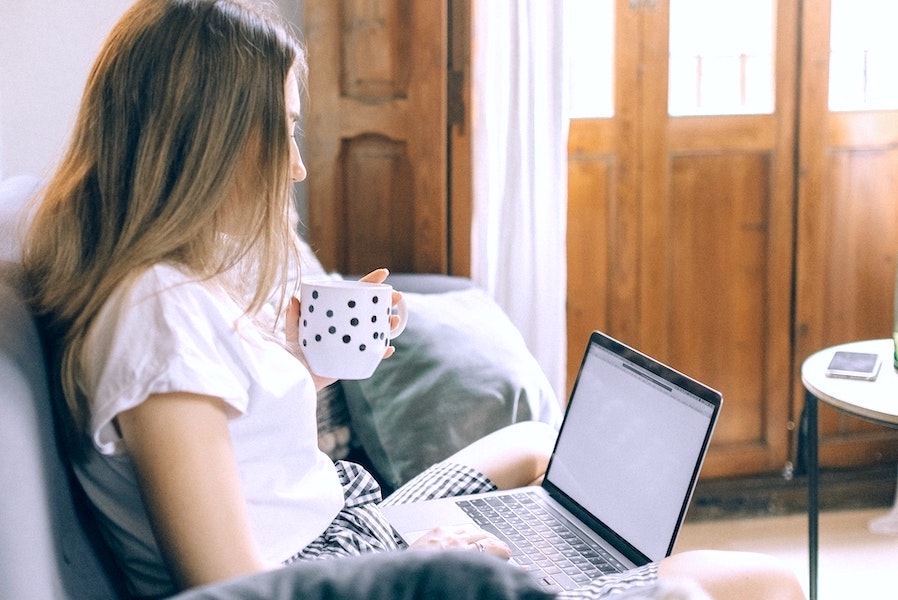 Woman logging in from home to hybrid work job.