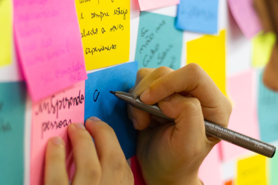 Employee writing on a post-it note.