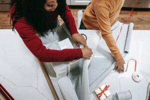 Two people wrapping holiday gifts.