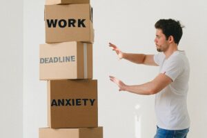 Man managing boxes with words work, deadline, and anxiety.