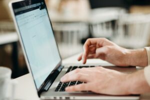 Hands typing on a laptop.