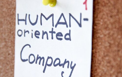 Post-it note on a bulletin board that says "human-oriented company."