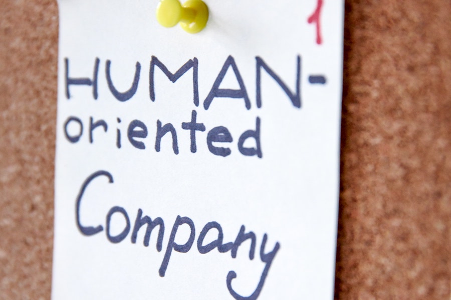 Post-it note on a bulletin board that says "human-oriented company."