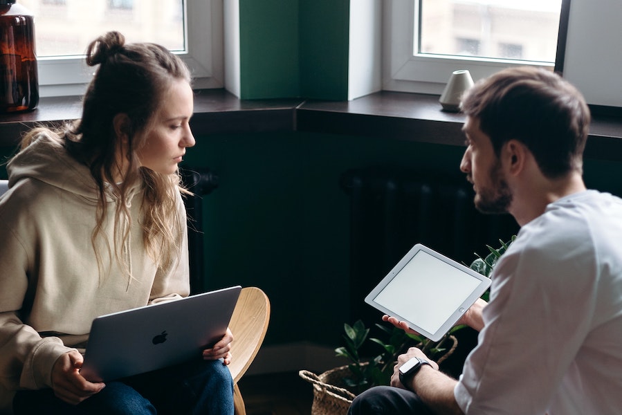 Workers looking at a laptop and a tablet.