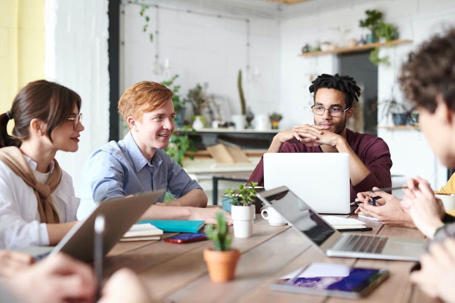 Young workers around a table having a meeting.