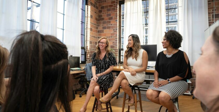 Three women leading a discussion in an office.