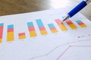 Colored chart and pen pointing to data.