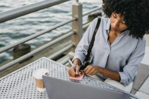 Woman next to the water writing a job description.