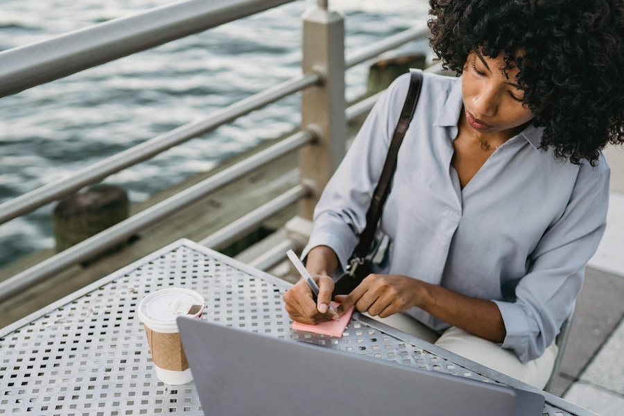 Woman next to the water writing a job description.