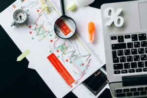 A table with a laptop, charts, and supplies.