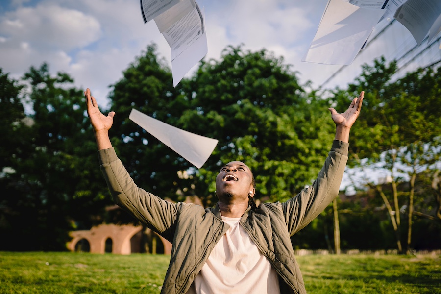 Throwing paperwork in the air and smiling.