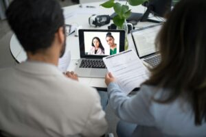 Two professionals talking to two other professionals online, via video chat.