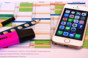 Phone with social apps sitting on a schedule sheet.