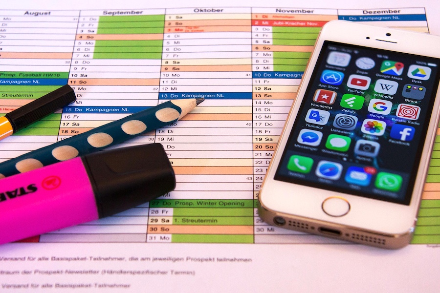 Phone with social apps sitting on a schedule sheet.