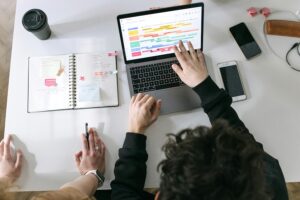 Coworkers looking at a planning calendar on a laptop.