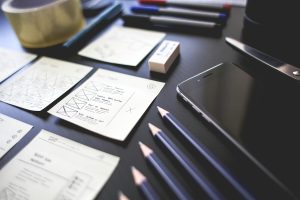 Notes, pencils, and technology on a table. In place for workforce planning.