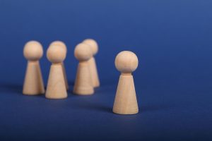A group of wood pieces against a blue background with one standing out from the others.