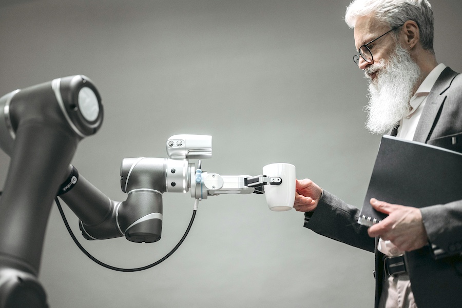 A robot handing a man a cup of coffee,